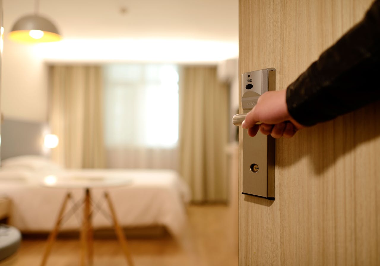 services-07 A soft-lit hotel room entrance, welcoming guests with luxury appeal and comfort.